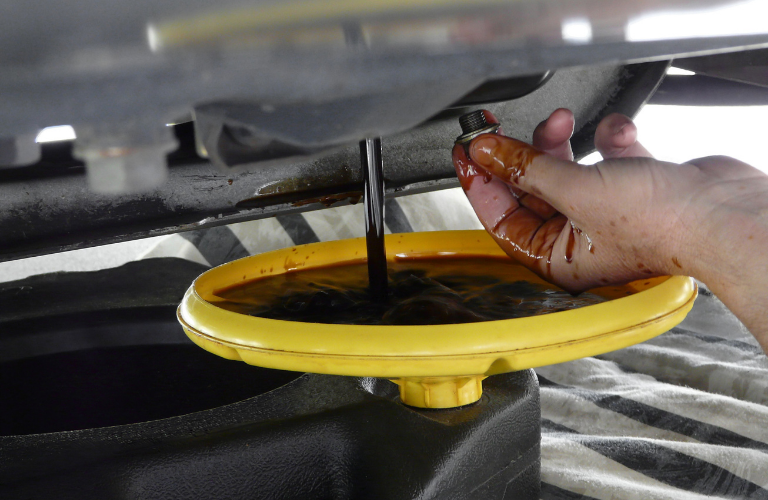 Mechanic changing oil of a vehicle