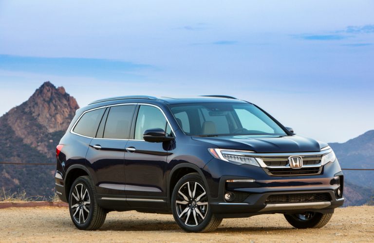 Front three-quarter view of the 2021 Honda Pilot near a hill