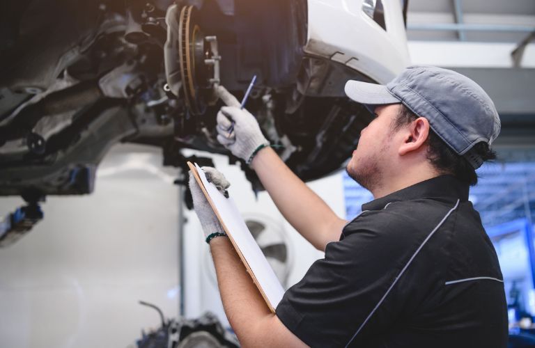 Technician inspecting brake of a vehicle