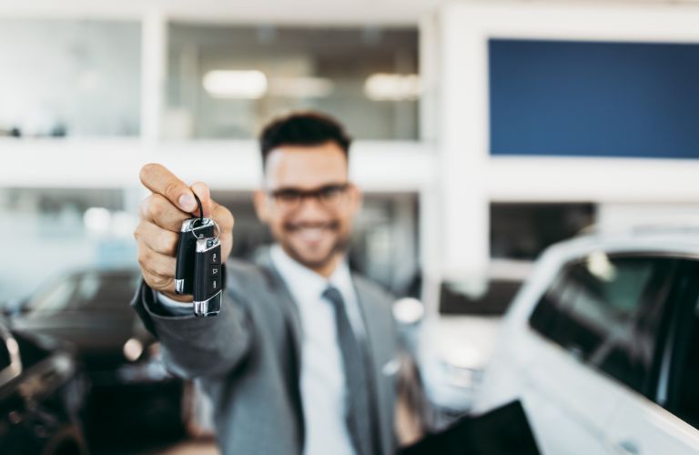 Sales person holding a car key