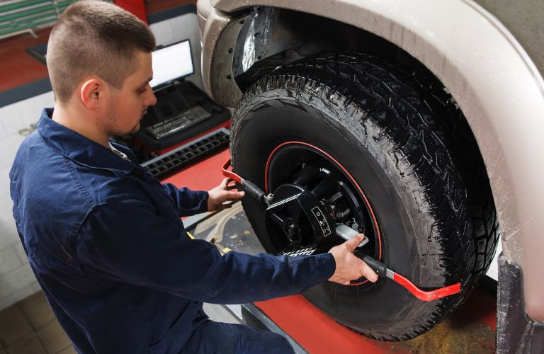 Technician aligning wheels of a vehicle