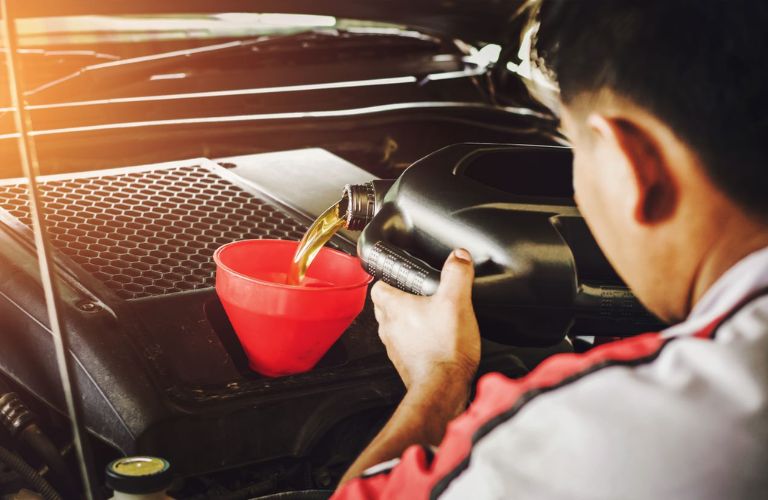 Technician pouring fresh oil